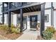 Inviting townhome front door with black trim, wreath and covered porch with room to sit at 1053 Knoxboro Ln, Woodstock, GA 30188