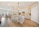 Bright open kitchen with a large island, white cabinetry, stainless steel appliances, and hardwood floors at 1053 Knoxboro Ln, Woodstock, GA 30188