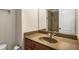 Bathroom featuring a brown vanity, tan countertop, mirror, toilet, and tiled shower at 380 Grant Se Cir # 110, Atlanta, GA 30315
