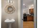 Elegant bathroom with a pedestal sink, round mirror and a glimpse into the kitchen at 380 Grant Se Cir # 110, Atlanta, GA 30315