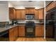 Well-lit kitchen featuring wooden cabinets, black appliances, and granite countertops at 380 Grant Se Cir # 110, Atlanta, GA 30315