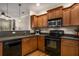Kitchen with wooden cabinets, black appliances, and stone countertops at 380 Grant Se Cir # 110, Atlanta, GA 30315