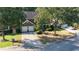 Aerial view of a home with well-maintained lawn, two-car garage, and beautiful surrounding landscape at 4770 Shiloh Springs Rd, Cumming, GA 30040