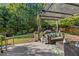 Lush backyard oasis featuring a covered patio, manicured lawn, and serene wooded views at 4770 Shiloh Springs Rd, Cumming, GA 30040