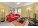 Versatile bonus room with a red sofa, modern coffee table, and neutral carpet at 4770 Shiloh Springs Rd, Cumming, GA 30040