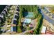 Aerial view of a community pool and tennis courts surrounded by lush trees, amenities and parking at 4770 Shiloh Springs Rd, Cumming, GA 30040