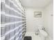 Bathroom featuring a gray and white striped shower curtain, toilet and art on the wall at 2161 Peachtree Ne Rd # 405, Atlanta, GA 30309