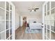 View of a bedroom through french doors, showcasing wood floors and a ceiling fan at 2161 Peachtree Ne Rd # 405, Atlanta, GA 30309