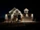 Exterior view of home at night with accent lighting highlighting the stonework at 231 Laurel Vista Dr, Canton, GA 30114