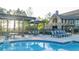 Community pool with seating and pergola detail with access to clubhouse featuring stone and siding exterior at 231 Laurel Vista Dr, Canton, GA 30114