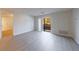 Bright living room features neutral walls, gray wood floors, and sliding glass doors to a balcony at 300 Johnson Ferry Ne Rd # B113, Atlanta, GA 30328