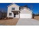Charming two-story home featuring a light gray exterior, a two-car garage, and a well-maintained front yard at 8516 Polston Place Dr, Douglasville, GA 30134