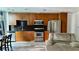 Open kitchen with wooden cabinets, stainless steel appliances, and black backsplash at 943 Peachtree Ne St # 704, Atlanta, GA 30309