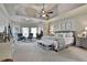 Generous main bedroom features a tray ceiling, sitting area, and neutral décor at 160 Isleworth Way, Fayetteville, GA 30215