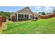 View of backyard featuring lawn, small wood deck, and screened-in porch at 1602 Renaissance Ne Dr, Conyers, GA 30012