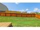 View of fenced-in yard featuring grass and small wood deck at 1602 Renaissance Ne Dr, Conyers, GA 30012