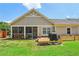Lawn view of backyard featuring small wood deck, garden beds, and screened-in porch at 1602 Renaissance Ne Dr, Conyers, GA 30012