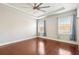 Large bedroom with hardwood floors, tray ceilings, a ceiling fan, and plenty of natural light at 1602 Renaissance Ne Dr, Conyers, GA 30012