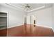 Bright bedroom with hardwood floors, tray ceiling with ceiling fan, and multiple entryways at 1602 Renaissance Ne Dr, Conyers, GA 30012