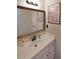 Bathroom vanity with white cabinets, mirror, and decorative elements on the wall at 1023 Spruce Creek Ln, Lawrenceville, GA 30045