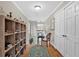Bright hallway with hardwood floors, showcases display shelving, leading to rooms and stairwell at 4144 D Youville Trce, Atlanta, GA 30341