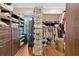 Organized walk-in closet with custom shelving, clothing racks, and hardwood floors at 4144 D Youville Trce, Atlanta, GA 30341
