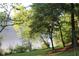 Picturesque lake view through lush foliage and lawn, perfect for enjoying nature at 711 Cypress Pointe St, Johns Creek, GA 30022
