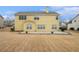 Home featuring a yellow exterior, patio, and spacious grassy backyard at 750 Beckenham Walk Dr, Dacula, GA 30019