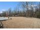 Spacious backyard with dry grass, stone patio, and mature trees at 750 Beckenham Walk Dr, Dacula, GA 30019