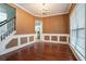 Elegant dining room featuring wainscoting, a chandelier, hardwood floors, and natural light, perfect for hosting gatherings at 750 Beckenham Walk Dr, Dacula, GA 30019