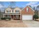 Charming two-story home with brick and siding exterior, red shutters, well-manicured landscaping, and two car garage at 750 Beckenham Walk Dr, Dacula, GA 30019