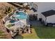 Aerial view of a backyard featuring a custom pool with a hot tub, a patio, and a cozy seating area with a fire pit at 330 Peninsula Pt, Canton, GA 30115