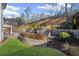 The backyard features a stone patio, a fire pit, and landscaping against the backdrop of a grassy hillside at 330 Peninsula Pt, Canton, GA 30115