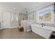Elegant bathroom with a freestanding tub, glass-enclosed shower, and plantation shutters at 330 Peninsula Pt, Canton, GA 30115
