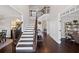 Bright foyer boasts a staircase with dark wood banister, wainscoting detail, and hardwood floors leading to living spaces at 330 Peninsula Pt, Canton, GA 30115