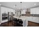 This kitchen features white cabinets, stainless steel appliances and a large kitchen island with bar stool seating at 330 Peninsula Pt, Canton, GA 30115
