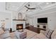 Open concept living room features stone fireplace, coffered ceiling, hardwood floors, and a large TV for entertaining at 330 Peninsula Pt, Canton, GA 30115