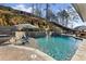 Beautiful backyard pool with tanning ledge, tiered stone retaining wall and water feature at 330 Peninsula Pt, Canton, GA 30115