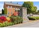 Community entrance sign set amongst colorful flower beds and brick pillars at 330 Peninsula Pt, Canton, GA 30115