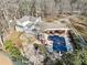 Aerial showing back of house, deck, pool with slide, gazebo, and poolhouse, all surrounded by wooded backyard at 444 Pineview Dr, Canton, GA 30114