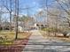 Long paved driveway leading to a well maintained home on a sprawling, wooded lot on a clear day at 444 Pineview Dr, Canton, GA 30114