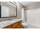 Bathroom with granite countertop, wood cabinets, and combination shower and tub at 5745 River Ridge Ln, Sugar Hill, GA 30518