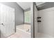 This bathroom features a soaking tub, a combination shower and tub, and a window for natural light at 5745 River Ridge Ln, Sugar Hill, GA 30518