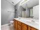 Bathroom with double sinks, wood cabinets, tile floors, and a combination shower and tub at 5745 River Ridge Ln, Sugar Hill, GA 30518