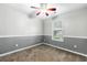 Bedroom with gray and white walls, neutral carpet, ceiling fan, and natural light from the window at 5745 River Ridge Ln, Sugar Hill, GA 30518