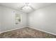 This bedroom features neutral carpet, gray walls, and a window for natural light at 5745 River Ridge Ln, Sugar Hill, GA 30518