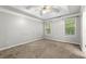 Bedroom with a tray ceiling, ceiling fan, neutral carpet, and natural light from two windows at 5745 River Ridge Ln, Sugar Hill, GA 30518