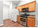 Efficient kitchen features stainless steel appliances, wood cabinets, and modern countertops at 5745 River Ridge Ln, Sugar Hill, GA 30518