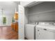 Laundry area including washer, dryer, and shelving, adjacent to the dining area at 5745 River Ridge Ln, Sugar Hill, GA 30518