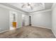 Main bedroom with a ceiling fan, neutral carpet, an en suite bath, and a walk-in closet at 5745 River Ridge Ln, Sugar Hill, GA 30518
